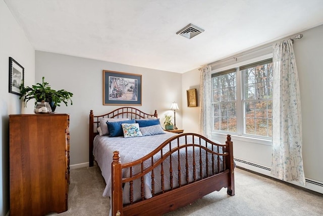 bedroom with a baseboard heating unit and light colored carpet