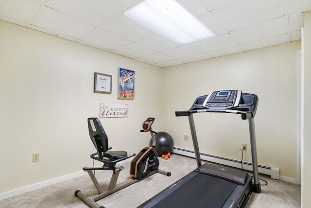 exercise room with a baseboard heating unit, carpet floors, and a paneled ceiling