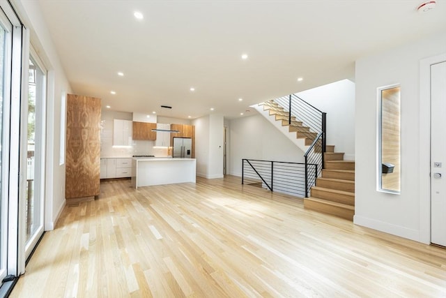 93 Griswold St Unit 93, Cambridge, MA 02138 - unfurnished living room with light wood finished floors, stairway, baseboards, and recessed lighting