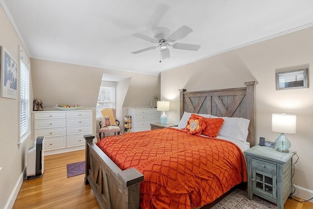 bedroom with light wood-style floors, ornamental molding, baseboards, and ceiling fan