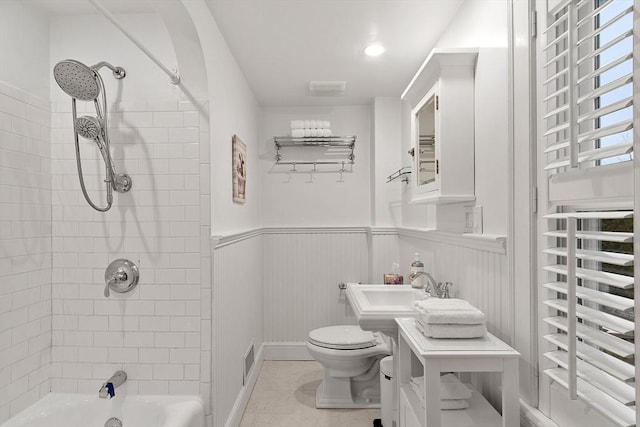 full bathroom featuring visible vents, toilet, a wainscoted wall, radiator, and shower / bathtub combination