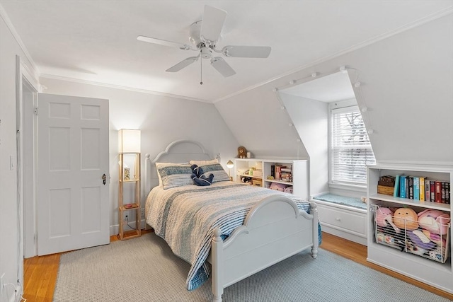 bedroom featuring ornamental molding, a ceiling fan, vaulted ceiling, and wood finished floors