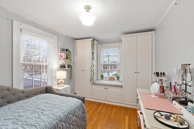 bedroom with light wood finished floors and crown molding