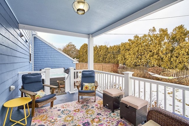 deck with a fenced backyard and a hot tub