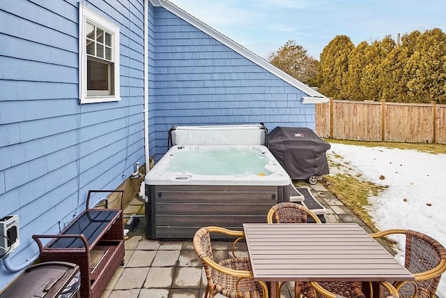 view of patio with outdoor dining space, area for grilling, fence, and a hot tub