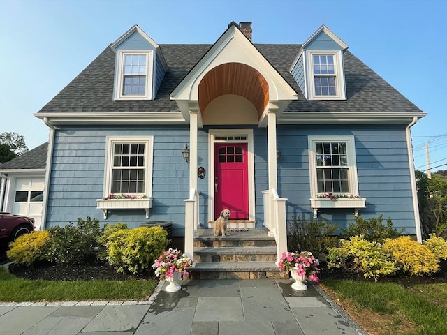 cape cod home with roof with shingles and a chimney