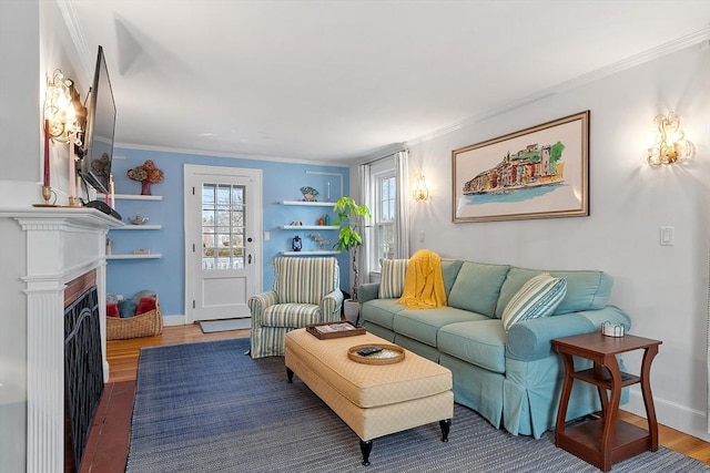 living room with ornamental molding, a fireplace, wood finished floors, and baseboards