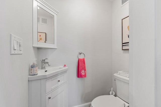 half bathroom with toilet, visible vents, and vanity