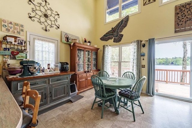 64 Porcupine Point Rd, Tolland, MA 01034 - dining area featuring a towering ceiling, healthy amount of natural light, a water view, and light flooring