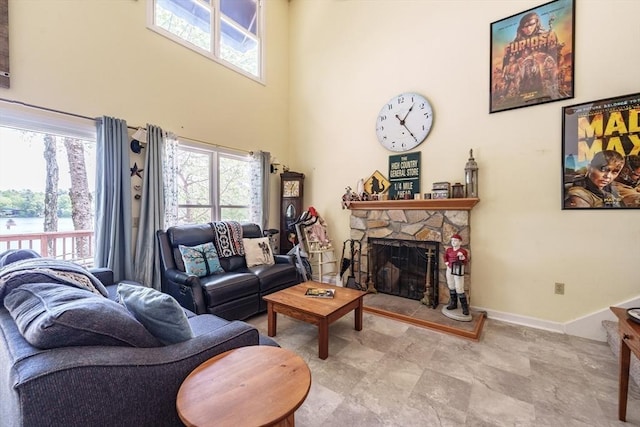 64 Porcupine Point Rd, Tolland, MA 01034 - living area featuring plenty of natural light, a fireplace, a high ceiling, baseboards, and a water view