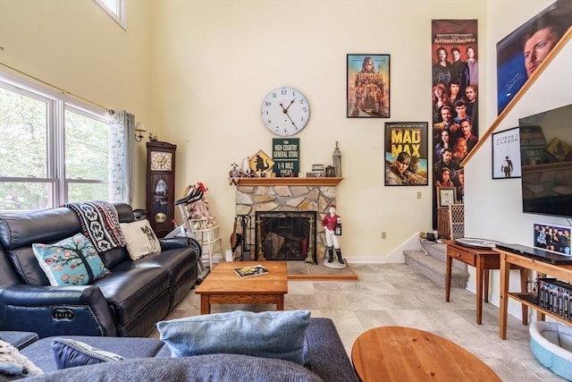 64 Porcupine Point Rd, Tolland, MA 01034 - living area with healthy amount of natural light, a towering ceiling, a fireplace, and baseboards