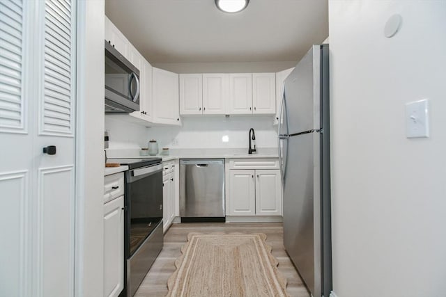 45 Macy St Unit 200A, Amesbury, MA 01913 - kitchen with appliances with stainless steel finishes, white cabinets, light countertops, and light wood-style floors