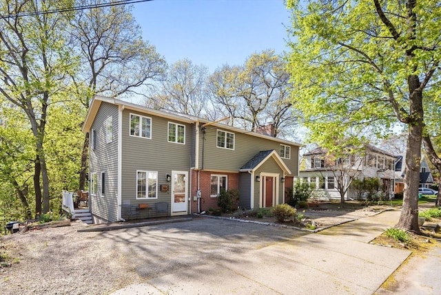 43 Grove Hill Park, Newton, MA 02460 - view of front of house with driveway, a chimney, and brick siding
