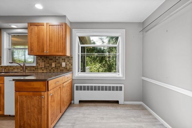 43 Grove Hill Park, Newton, MA 02460 - kitchen with radiator, a sink, backsplash, dark countertops, and light wood-style flooring