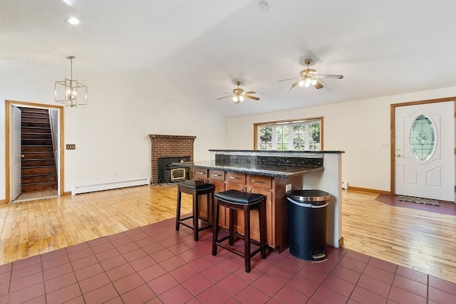 728 River St, Winchendon, MA 01475 - kitchen with a baseboard radiator, dark wood-type flooring, a ceiling fan, vaulted ceiling, and a kitchen breakfast bar