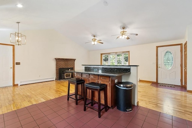 728 River St, Winchendon, MA 01475 - kitchen featuring baseboard heating, a ceiling fan, a breakfast bar area, vaulted ceiling, and dark wood finished floors