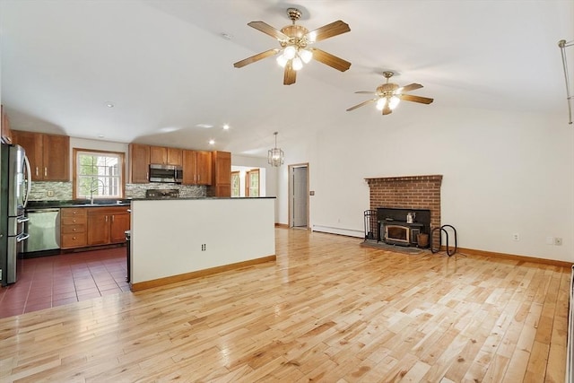 728 River St, Winchendon, MA 01475 - kitchen featuring appliances with stainless steel finishes, open floor plan, dark countertops, decorative backsplash, and light wood-style flooring