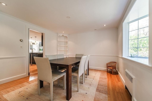 dining room featuring radiator heating unit, recessed lighting, ornamental molding, and light wood finished floors