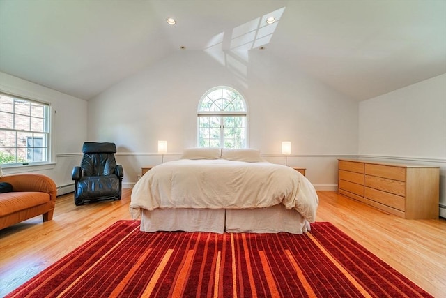 bedroom with baseboards, vaulted ceiling, wood finished floors, and a baseboard radiator