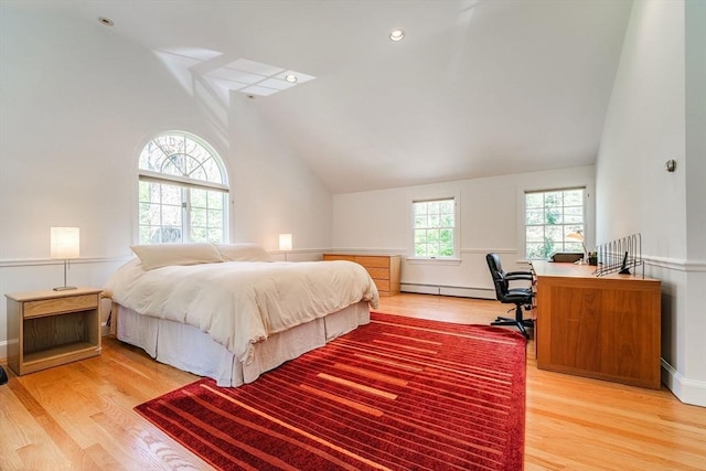 bedroom featuring light wood-style floors, a baseboard radiator, and high vaulted ceiling