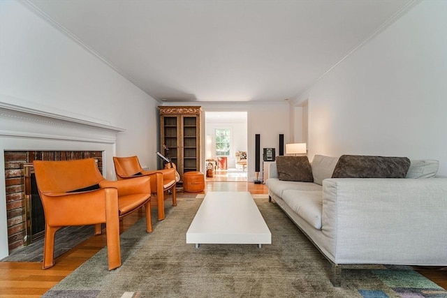 living area featuring crown molding, wood finished floors, and a fireplace