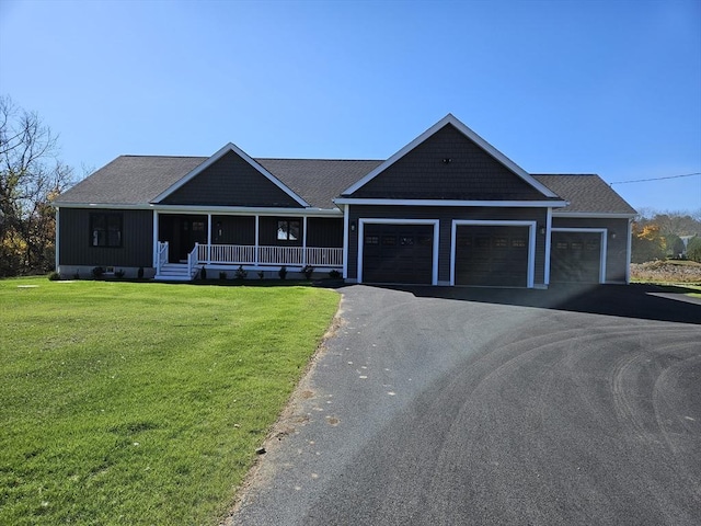 view of front of home featuring a garage, a front yard, and a porch