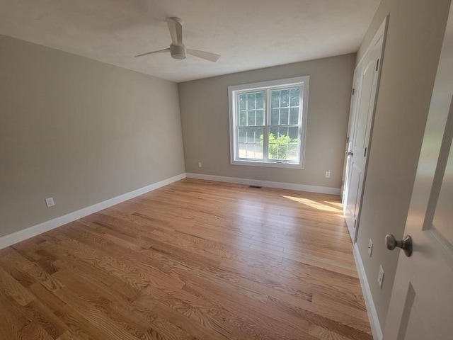 spare room with light wood-type flooring and ceiling fan