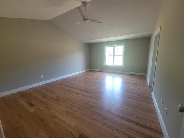 empty room with light hardwood / wood-style floors, vaulted ceiling, and ceiling fan