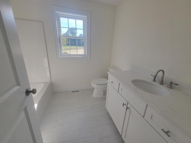 bathroom featuring vanity, tile patterned flooring, toilet, and a tub