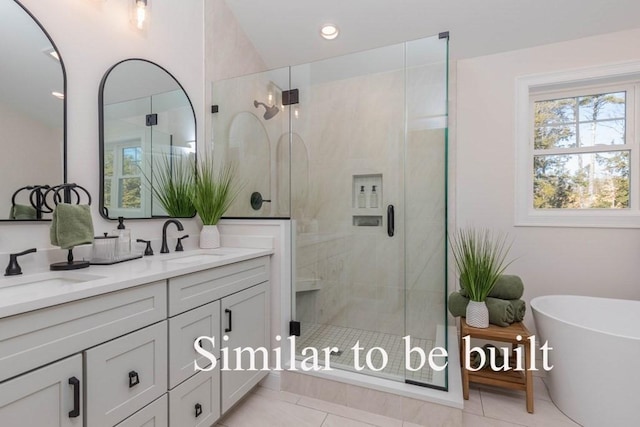 bathroom featuring a freestanding bath, a shower stall, double vanity, and a sink