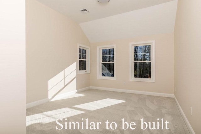 carpeted empty room with visible vents, baseboards, and vaulted ceiling