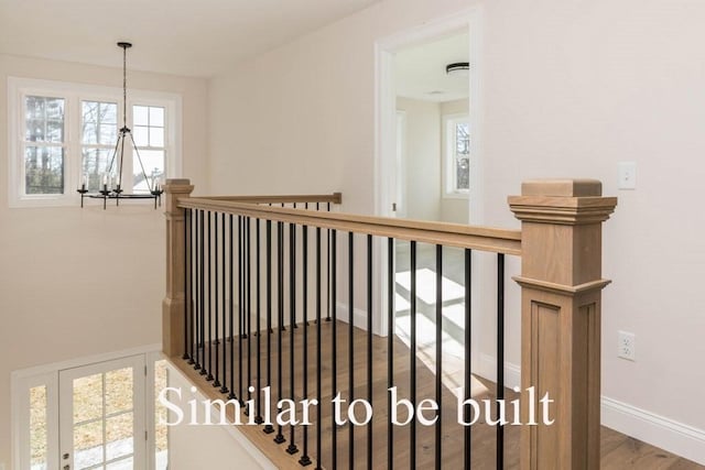 stairs featuring an inviting chandelier, wood finished floors, and baseboards