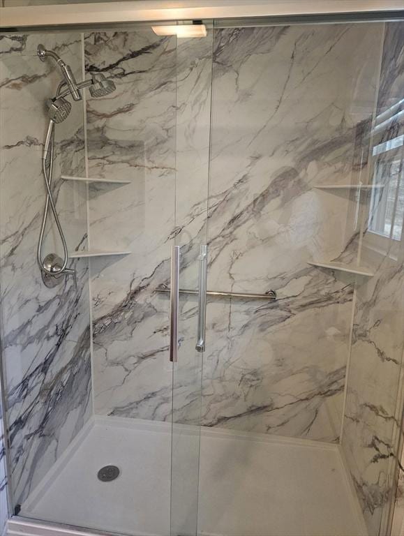 bathroom with a marble finish shower