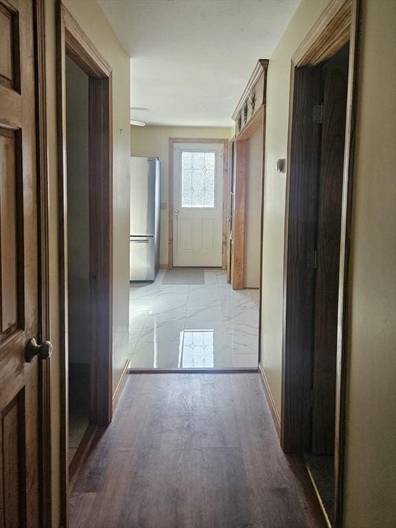 hallway featuring baseboards and light wood-type flooring
