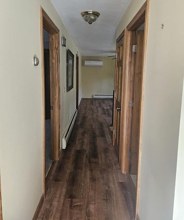 hallway with an AC wall unit, a baseboard heating unit, and dark wood-style floors