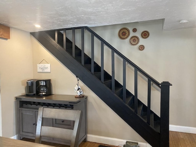 staircase featuring baseboards and wood finished floors