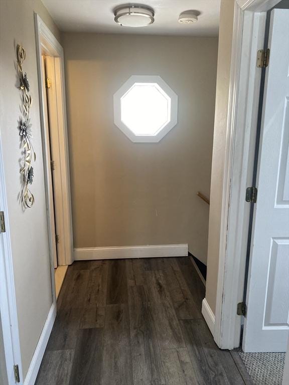 hallway with baseboards and dark wood-type flooring