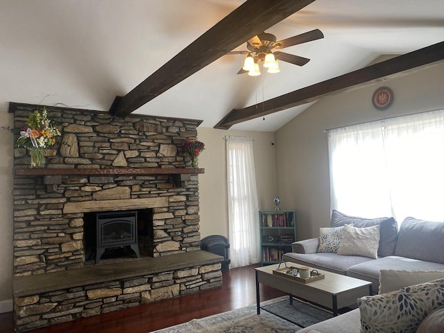 living area with a ceiling fan, vaulted ceiling with beams, a wood stove, and wood finished floors
