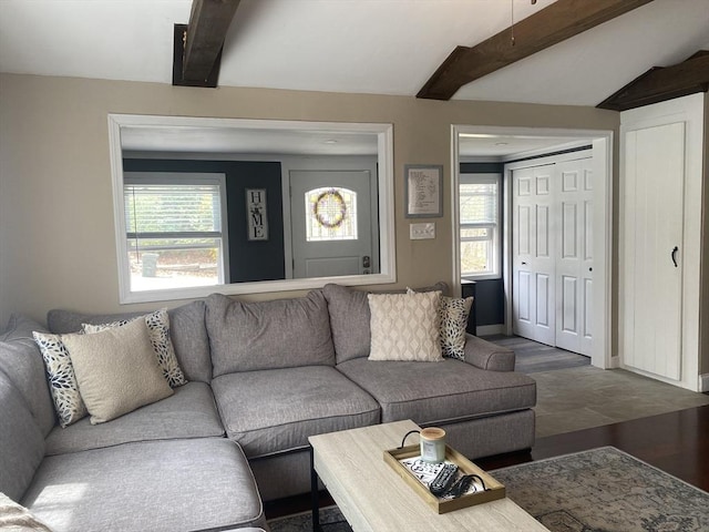 living area featuring baseboards, beamed ceiling, and wood finished floors