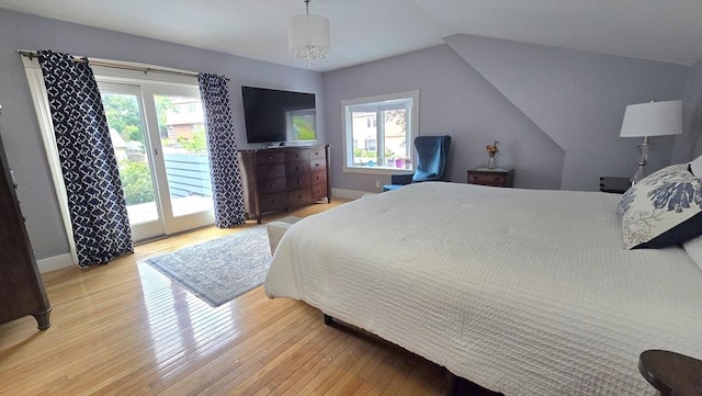 9 Venner Rd, Arlington, MA 02476 - bedroom with access to exterior, light wood-style flooring, lofted ceiling, baseboards, and a chandelier