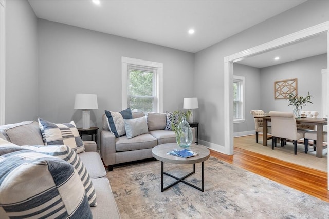 living room featuring light wood finished floors, recessed lighting, and baseboards