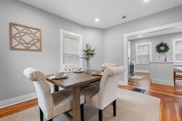 dining space with light wood-style floors, baseboards, and recessed lighting