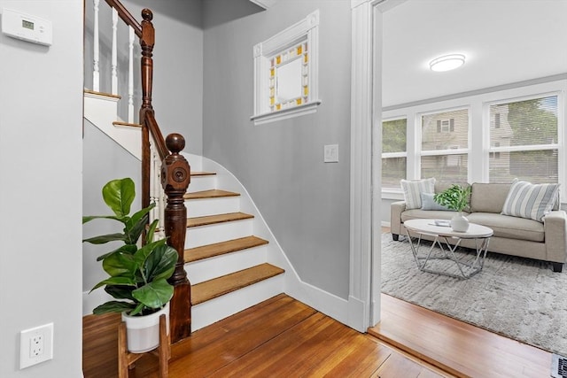 stairs featuring wood-type flooring and baseboards