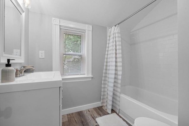 full bath with wood finished floors, baseboards, shower / tub combo, vanity, and lofted ceiling