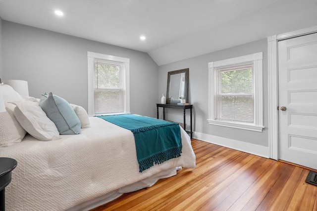 bedroom with light wood finished floors, vaulted ceiling, multiple windows, baseboards, and recessed lighting