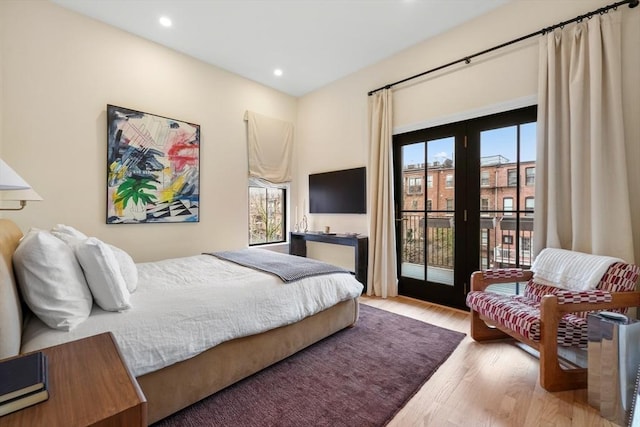 bedroom with access to exterior, wood finished floors, and recessed lighting