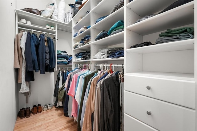 walk in closet with wood finished floors
