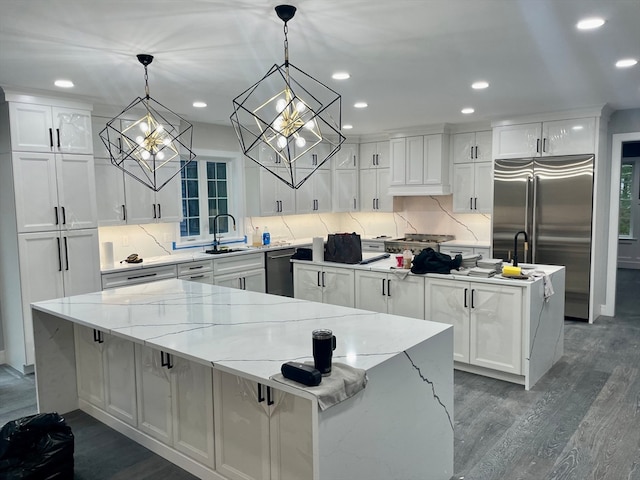 kitchen with hanging light fixtures, appliances with stainless steel finishes, a large island, and white cabinets