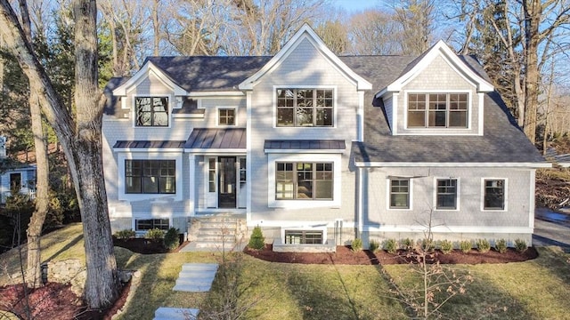 view of front of house featuring roof with shingles, a front lawn, and a standing seam roof