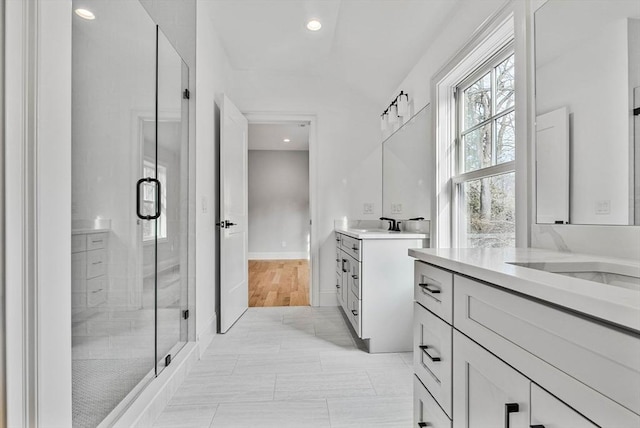 full bath featuring recessed lighting, a sink, a shower stall, and two vanities